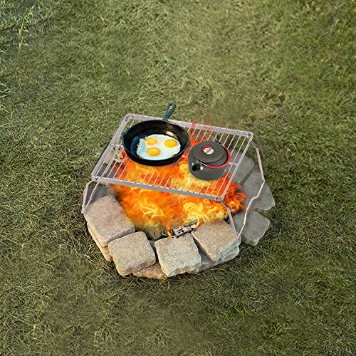 Grilling eggs on a campfire with a skillet on a stone fire pit.