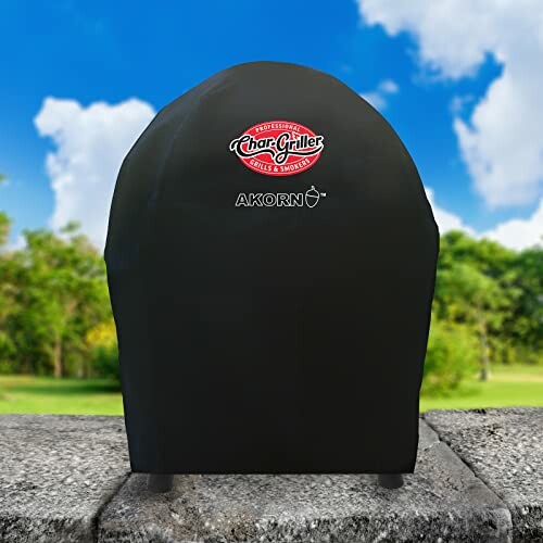 Char-Griller Akorn grill cover on a stone surface with a garden background