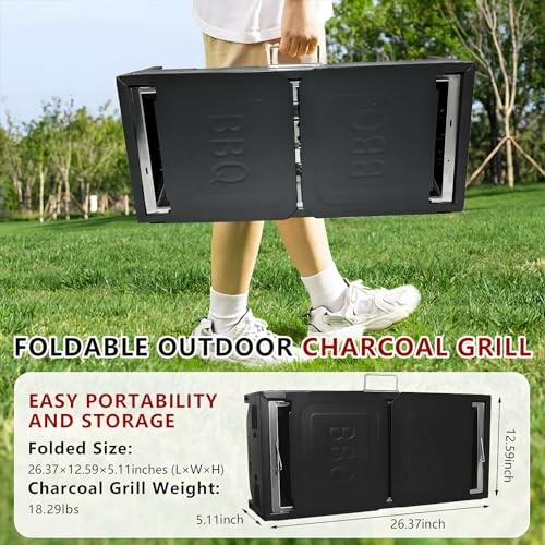 Person carrying a foldable outdoor charcoal grill in a park.