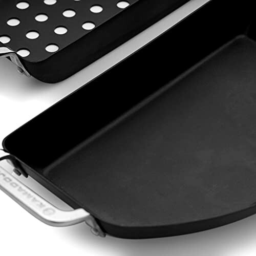 Close-up of a grill pan with perforated surface and a griddle.