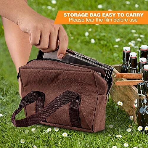 Hand placing an item in a brown storage bag on grass beside a crate of bottles.